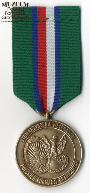 1. Nazwa własna: medal „Za zasługi w propagowaniu tradycji ochrony polskich granic”
2. Charakterystyka przedmiotu: medal powołany uchwałą nr 1 z 18.04.2019 r. Zarządu Stowarzyszenia Weteranów Polskich Formacji Granicznych, zaprojektowany przez Andrzeja Olichwiruka. Okrągły, barwy brązowej, bity w metalu, o średnicy 38 mm, częściowo emaliowany. Na awersie w polu środkowym znajduje się biało-czerwony słup graniczny z orłem państwowym na czerwonej tarczy herbowej. Po bokach wieniec laurowy spięty dołem czteropromienną gwiazdą. Na obwodzie medalu dwa pierścienie, pomiędzy którymi znajduje się napis „ZA ZASŁUGI W POPULARYZOWANIU TRADYCJI OCHRONY POLSKICH GRANIC” na tle zielonym. Na rewersie w polu środkowym logo Stowarzyszenia w postaci odznaki Korpusu Ochrony Pogranicza „Za Służbę Graniczną” wpisanej w orła wz. 19. Na obwodzie medalu dwa pierścienie, pomiędzy którymi znajduje się napis „STOWARZYSZENIE WETERANÓW POLSKICH FORMACJI GRANICZNYCH”. Wstążka odznaczenia ma szerokość 38 mm, składa się z dwóch zewnętrznych pasów koloru zielonego o szerokości po 11 mm, w środku pas biało-czerwony o szer. 10 mm, który oddzielony jest od zieleni dwoma paskami granatowymi o szer. po 3 mm. Szerokość baretki medalu równa jest szerokości wstążki, a wysokość wynosi 8 mm.
3. Czas powstania: 2019 r.
4. Hasła przedmiotowe: Straż Graniczna, miejsca pamięci
5. Miejsce przechowywania/właściciel: zbiory prywatne