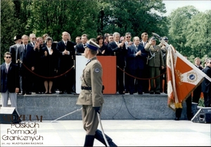 1. Tytuł: obchody rocznicy uchwalenia Konstytucji 3 Maja
2. Opis obrazu: defilada żołnierzy Kompanii Reprezentacyjnej Wojska Polskiego
3. Data wydarzenia: 03.05.1998 r. 
4. Osoby widoczne: w pierwszym rzędzie od lewej: Janusz Onyszkiewicz,  Minister Obrony Narodowej, Alicja Grześkowiak, Marszałek Senatu RP,  Maciej Płażyński, Marszałek Sejmu RP, Aleksander Kwaśniewski,  Prezydent RP (przemawiający), Jolanta Kwaśniewska, Małżonka Prezydenta RP,  Jerzy Buzek, Prezes Rady Ministrów, Janusz Tomaszewski,  Minister Spraw Wewnętrznych i Administracji, gen. broni, szef Sztabu  Generalnego Wojska Polskiego.  W drugim rzędzie od lewej: Pinchas Menachem Jaskowicz, naczelny rabin Polski, Bronisław Geremek, Minister Spraw Zagranicznych, Sławoj Leszek Głódź,  Biskup Polowy Wojska Polskiego
5. Hasła przedmiotowe: Straż Graniczna, święta państwowe
6. Opis techniczny: oryginał, kolorowe
7. Autor: Marek Krupa
8. Miejsce przechowywania/właściciel: Archiwum Straży Granicznej w Szczecinie