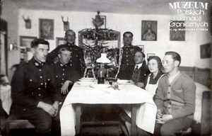 1. Tytuł tematu: wigilia
2. Opis obrazu: funkcjonariusze Straży Granicznej podczas wigilii w Dołhopolu
3. Data wydarzenia: 1929 r.
4. Osoby widoczne: od lewej – „Urbaniak, Kiendlaż, Welter, Chmielnik, Hubyczuk, Maryśka”
5. Hasła przedmiotowe: Straż Graniczna, życie rodzinne
6. Opis techniczny: oryginał, czarnobiałe
7. Autor: brak danych
8. Miejsce przechowywania/właściciel: Waldemar Bocheński