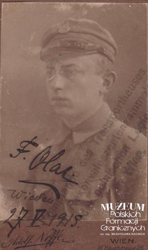 1. Tytuł: identyfikator legionowy 
2. Opis obrazu: zdjęcie Feliksa Olasa potwierdzone na odwrocie przez Komendę Placu w Wiedniu
3. Data wydarzenia: 29.05.1915 r.
4. Osoby widoczne: Feliks Olas
5. Hasła przedmiotowe: kadra
6. Opis techniczny: oryginał, czarnobiałe
7. Autor: Rudolf Neffe
8. Miejsce przechowywania/właściciel: Andrzej Olas