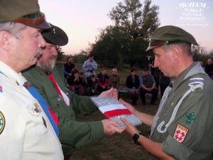 1. Tytuł tematu: ognisko harcerskie poświęcone pamięci żołnierzy  Korpusu Ochrony Pogranicza
2. Opis obrazu: przekazanie przez prezesa SWPFG Waldemara Bocheńskiego  odlewu tablicy z granicy polsko – radzieckiej z okresu międzywojennego 
	 komendantowi Hufca Wołyń – phm Aleksandrowi Radicy
3. Data wydarzenia: 17.09.2011 r.
4. Osoby widoczne: phm Wojciech Grobelski (pierwszy z lewej), phm Waldemar 
	 Bocheński (drugi z lewej), phm Aleksander Radica (pierwszy z prawej)
5. Hasła przedmiotowe: miejsca pamięci
6. Opis techniczny: oryginał, kolorowe
7. Autor: Edward Milewski
8. Miejsce przechowywania/właściciel: Wojciech Grobelski