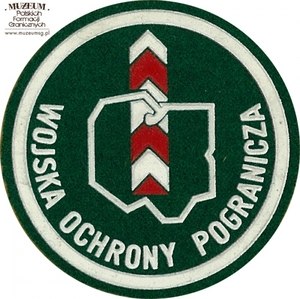 1. Nazwa własna: naszywka organizacyjna Dowództwa Wojsk Ochrony Pogranicza
2. Charakterystyka przedmiotu: okrągła plakietka (o średnicy 6,6 cm)  wykonana z filcu na podkładzie płóciennym. Obwiedziona białym paskiem,  w dolnej części półkoliście napis „Wojska Ochrony Pogranicza”. W centrum pola logo jednostki organizacyjnej – kontur Polski na tle słupa granicznego. Noszona na prawym przedramieniu marynarki i płaszcza munduru wyjściowego
3. Czas powstania: lata 80. XX w.
4. Hasła przedmiotowe: Wojska Ochrony Pogranicza, umundurowanie
5. Miejsce przechowywania/właściciel: Śląski Oddział Straży Granicznej  w Raciborzu
