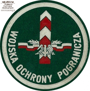 1. Nazwa własna: naszywka organizacyjna Nadbużańskiej Brygady  Wojsk Ochrony Pogranicza
2. Charakterystyka przedmiotu: okrągła plakietka (o średnicy 6,6 cm) wykonana z filcu na podkładzie płóciennym. Obwiedziona białym paskiem, w dolnej  części półkoliście napis „Wojska Ochrony Pogranicza”. W centrum pola logo  jednostki organizacyjnej – orzeł na tle słupa granicznego z szarfami  i elementami roślinnym. Motyw ten nawiązuje do Manifestu Lipcowego  z 22.07.1944 r. Noszona na prawym przedramieniu marynarki płaszcza  munduru wyjściowego
3. Czas powstania: lata 80. XX w.
4. Hasła przedmiotowe: Wojska Ochrony Pogranicza, umundurowanie
5. Miejsce przechowywania/właściciel: Śląski Oddział Straży Granicznej  w Raciborzu