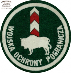 1. Nazwa własna: naszywka organizacyjna Podlasko - Mazurskiej Brygady  Wojsk Ochrony Pogranicza.
2. Charakterystyka przedmiotu: okrągła plakietka (o średnicy 6,6 cm)  wykonana z filcu na podkładzie płóciennym. Obwiedziona białym paskiem,  w dolnej części półkoliście napis „Wojska Ochrony Pogranicza”. W centrum pola logo jednostki organizacyjnej – żubr na tle słupa granicznego.  Noszona na prawym przedramieniu marynarki i płaszcza munduru wyjściowego
3. Czas powstania: lata 80. XX w.
4. Hasła przedmiotowe: Wojska Ochrony Pogranicza, umundurowanie
5. Miejsce przechowywania/właściciel: Śląski Oddział Straży Granicznej  w Raciborzu