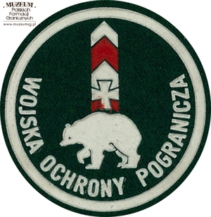 1. Nazwa własna: naszywka organizacyjna Bieszczadzkiej Brygady  Wojsk Ochrony Pogranicza
2. Charakterystyka przedmiotu: okrągła plakietka (o średnicy 6,6 cm)  wykonana z filcu na podkładzie płóciennym. Obwiedziona białym paskiem,  w dolnej części półkoliście napis „Wojska Ochrony Pogranicza”. W centrum  pola logo jednostki organizacyjnej – elementy herbu Przemyśla na tle słupa granicznego. Noszona na prawym przedramieniu marynarki i płaszcza  munduru wyjściowego
3. Czas powstania: lata 80. XX w.
4. Hasła przedmiotowe: Wojska Ochrony Pogranicza, umundurowanie
5. Miejsce przechowywania/właściciel: Śląski Oddział Straży Granicznej w Raciborzu