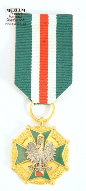 1.Nazwa własna: medal „Za Zasługi dla Straży Granicznej” – złoty 
2.Charakterystyka przedmiotu: medal jest zmodyfikowaną kontynuacją nadawanej wcześniej odznaki: „Za Zasługi w Ochronie Granic PRL”. Ustanowiony został na mocy Ustawy z dnia 8 października 2004 r. Wykonany ze stopu metali o wymiarach:3,5 x 3,5 x 0,3 cm. Na awersie obramowany jest wieńcem z liści laurowych i dębowych. W centralnym miejscu umieszczono czteroramienny, zielono emaliowany krzyż, zakończony na rogach kulkami i z wkomponowanym pośrodku wizerunkiem godła państwowego. Orzeł osadzony jest na tle słupa granicznego, którego pasy są emaliowane w kolorze białym i czerwonym, a kontury w kolorze szarym. Na rewersie, w wypukłym konturze przedstawiającym terytorium i granice Rzeczypospolitej Polskiej, umieszczony został napis: „ZA ZASŁUGI–DLA–STRAŻY GRANICZNEJ”. Medal zawieszony jest na wstążce koloru zielonego o szer. 3,5cm. Przez środek wstążki przebiega biało-czerwono-biały pasek o szerokości 1,5cm. Medal został przekazany przez Biuro Kadr i Szkolenia Komendy Głównej Straży Granicznej w Warszawie
3.Czas powstania: 2004 r.
4.Hasła przedmiotowe: Straż Graniczna, odznaczenia
5.Miejsce przechowywania/właściciel: Centralny Ośrodek Szkolenia SG w Koszalinie