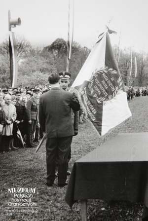 1.Tytuł tematu: uroczystość wręczenia sztandaru Łużyckiej Brygadzie Wojsk Ochrony Pogranicza
2.Opis obrazu: przedstawiciel Społecznego Komitetu Fundacji Sztandaru Łużyckiej Brygadzie WOP wręcza sztandar Dowódcy WOPgen. bryg. Eugeniuszowi Dostojewskiemu
3.Data wydarzenia: 12.05.1963 r.
4.Osoby widoczne: dowódca WOP gen. bryg. Eugeniusz Dostojewski (w centrum kadru) 
5.Hasła przedmiotowe: Wojska Ochrony Pogranicza, sztandary
6.Opis techniczny: 12 x 18 cm, oryginał, czarnobiałe
7.Autor: brak danych
8.Miejsce przechowywania/właściciel: Sala Tradycji Ośrodka Szkoleń  Specjalistycznych SG w Lubaniu