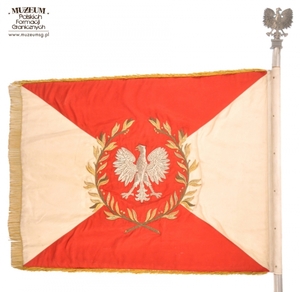 1.Nazwa własna: sztandar 9 Lubuskiej Brygady Wojsk Ochrony Pogranicza.
2.Charakterystyka przedmiotu: biały płat (130 x 100 cm) zszyty z dwóch trójkątów koloru białego (bocznych) i dwóch koloru czerwonego (górny i dolny).  Pośrodku na czerwonym tle,  obwiedzionym dwiema złotymi gałązkami wawrzynu,	umieszczono wizerunek orła państwowego. Na stronie odwrotnej centralnie, napis: „Za – Naszą Ojczyznę – Polską – Rzeczpospolitą – Ludową”, a poniżej nazwę jednostki: „9 Lubuska Brygada – Wojsk Ochrony Pogranicza”, otoczony gałązkami wawrzynu. W lewym górnym rogu na zszyciach biało-czerwonych pól herb Zielonej Góry, a w prawym rogu niebieska tarcza ze złoconą obwódką i złotym napisem: „Społeczeństwo – Województwa – Zielonogórskiego – 22.VII.1963 r.” Płat sztandaru obszyty złotymi frędzlami
3.Czas powstania: 1963 r.
4.Hasła przedmiotowe: Wojska Ochrony Pogranicza, sztandary
5.Miejsce przechowywania/ właściciel: Centralny Ośrodek Szkolenia Straży Granicznej w Koszalinie
