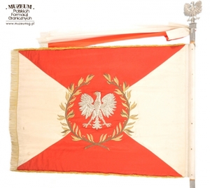 1.Nazwa własna: sztandar 12 Pomorskiej Brygady Wojsk Ochrony Pogranicza.
2.Charakterystyka przedmiotu: biały płat (130 x 100 cm) zszyty z dwóch trójkątów koloru białego (bocznych) i dwóch koloru czerwonego (górny i dolny). Pośrodku na czerwonym tle,  obwiedzionym dwiema złotymi gałązkami wawrzynu, umieszczono wizerunek orła państwowego. Na stronie odwrotnej widnieje napis: „Za – Naszą Ojczyznę – Polską – Rzeczpospolitą 
	– Ludową”, otoczony gałązkami wawrzynu, a poniżej nazwa jednostki: „12 Pomorska Brygada – Wojsk Ochrony Pogranicza”,. W lewym górnym rogu na zszyciach biało-czerwonych pól: niebieska tarcza ze złoconą obwódką i wizerunkiem czerwonego gryfa pomorskiego. W prawym rogu: identyczna tarcza niebieska ze złotym napisem: „Społeczeństwo – Ziemi – Szczecińskiej – 22.VII.1963 r.”
3.Czas powstania: 1963 r.
4.Hasła przedmiotowe: Wojska Ochrony Pogranicza, sztandary
5.Miejsce przechowywania/ właściciel: Centralny Ośrodek Szkolenia Straży Granicznej w Koszalinie