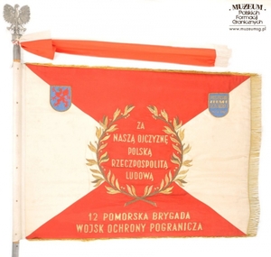 1.Nazwa własna: sztandar 12 Pomorskiej Brygady Wojsk Ochrony Pogranicza.
2.Charakterystyka przedmiotu: biały płat (130 x 100 cm) zszyty z dwóch trójkątów koloru białego (bocznych) i dwóch koloru czerwonego (górny i dolny). Pośrodku na czerwonym tle,  obwiedzionym dwiema złotymi gałązkami wawrzynu, umieszczono wizerunek orła państwowego. Na stronie odwrotnej widnieje napis: „Za – Naszą Ojczyznę – Polską – Rzeczpospolitą 
	– Ludową”, otoczony gałązkami wawrzynu, a poniżej nazwa jednostki: „12 Pomorska Brygada – Wojsk Ochrony Pogranicza”,. W lewym górnym rogu na zszyciach biało-czerwonych pól: niebieska tarcza ze złoconą obwódką i wizerunkiem czerwonego gryfa pomorskiego. W prawym rogu: identyczna tarcza niebieska ze złotym napisem: „Społeczeństwo – Ziemi – Szczecińskiej – 22.VII.1963 r.”
3.Czas powstania: 1963 r.
4.Hasła przedmiotowe: Wojska Ochrony Pogranicza, sztandary
5.Miejsce przechowywania/ właściciel: Centralny Ośrodek Szkolenia Straży Granicznej w Koszalinie